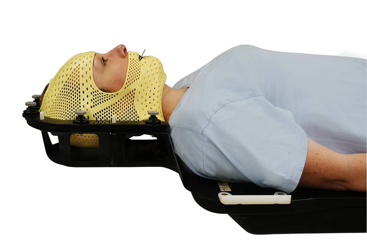 Patientin mit gelber thermoplastischer SRS-Maske auf der Kopf-Hals-Lagerung von Encompass